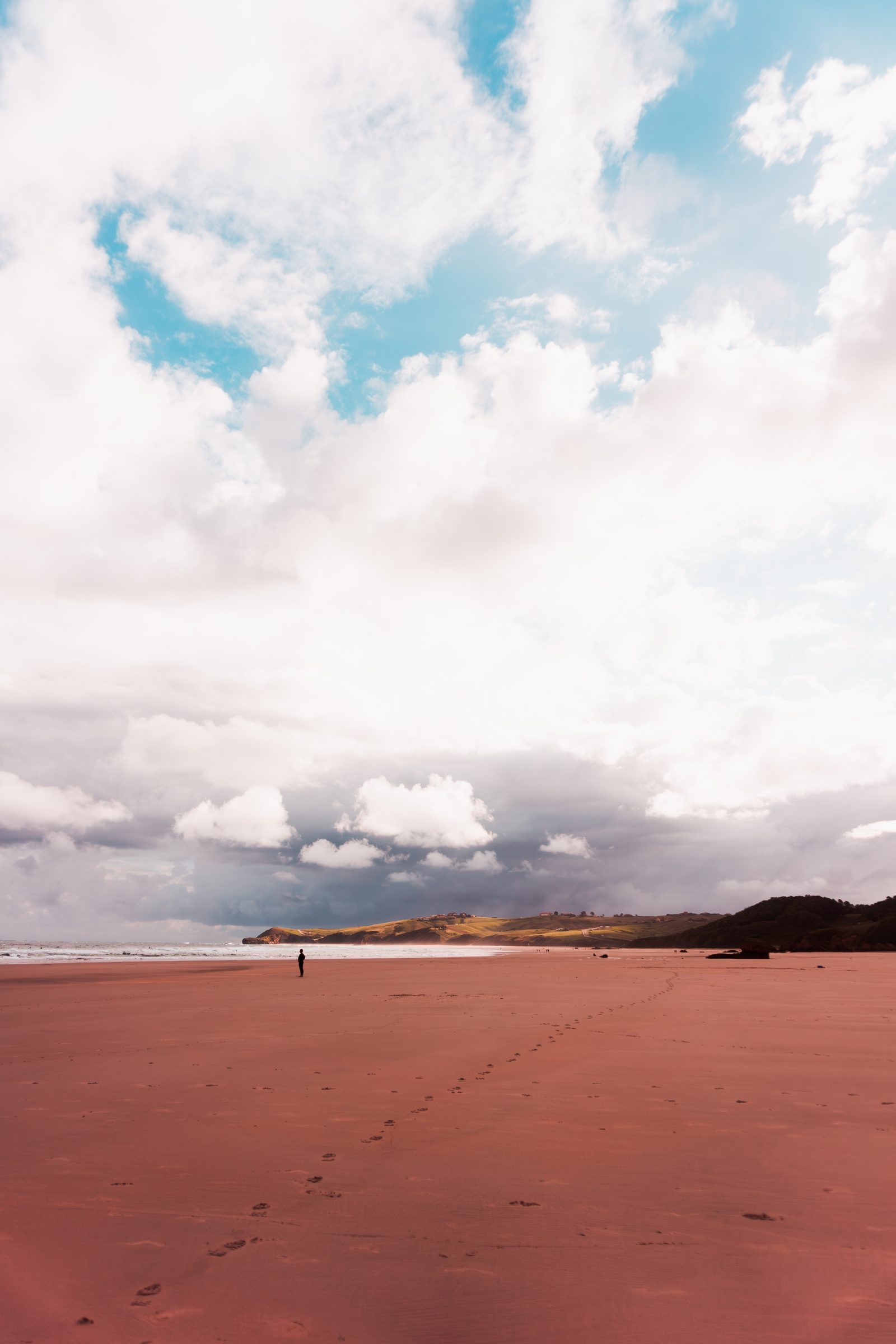 A single figure beneath an endless sky reminds us that even in vast solitude, love finds its way to walk beside us.
