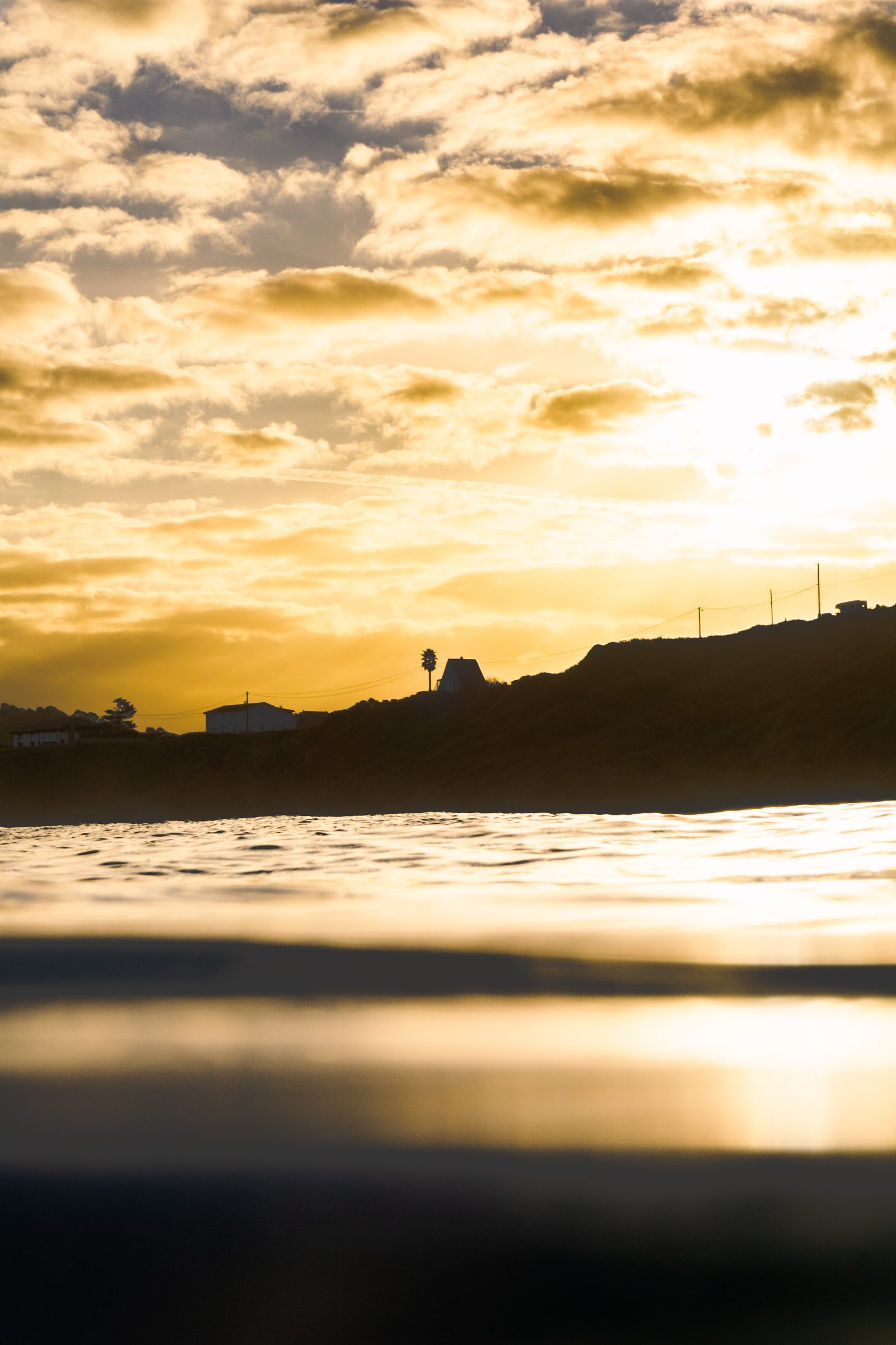Golden light spills across the water, wrapping the quiet shoreline in warmth—a reminder that even in stillness, the world holds us gently.