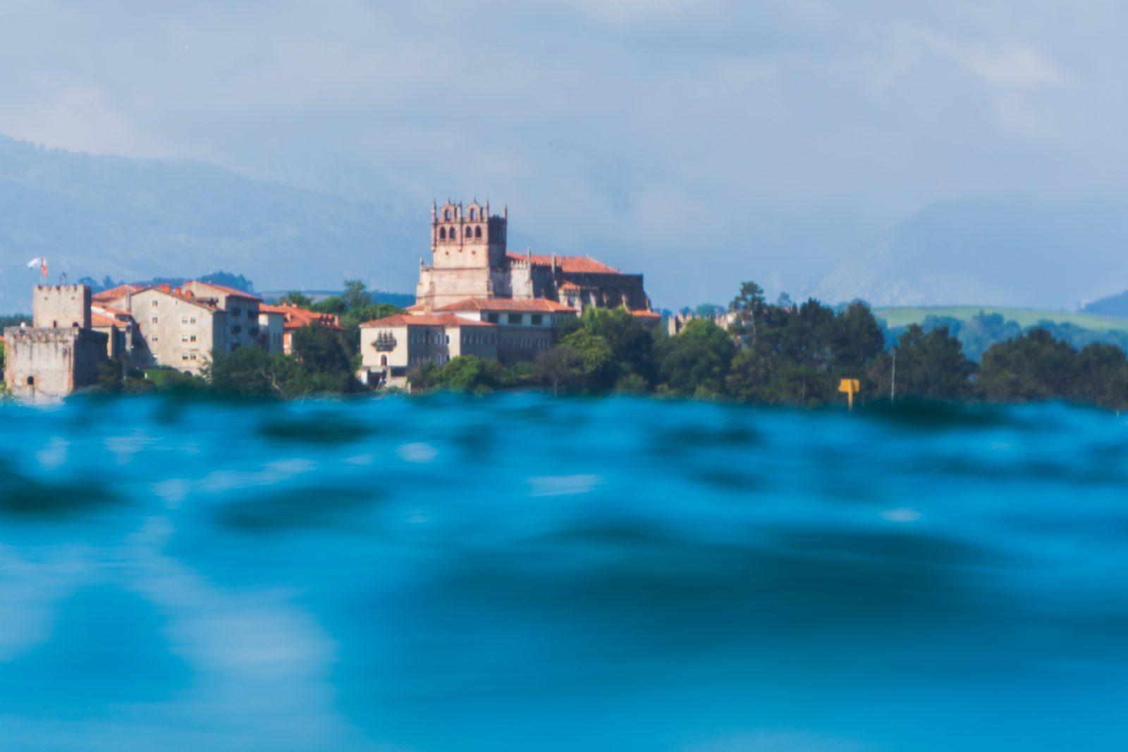 Like turquoise waves cradling an ancient town, love holds us close, blurring distance and time into one gentle embrace.