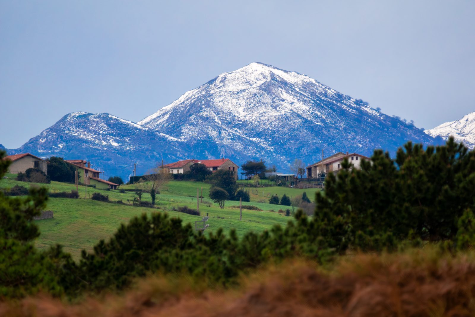 Beneath the snow-capped peaks standing steadfast through every season, the little village rests in the valley's embrace, home always holding us close.